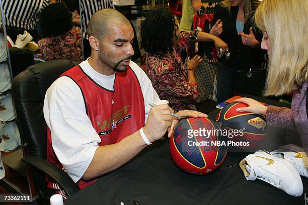 Carlos Boozer of the Utah Jazz signs autographs and greets customers during an appearance for NBA All-Star Week at Champs Sports Goods at the Las...