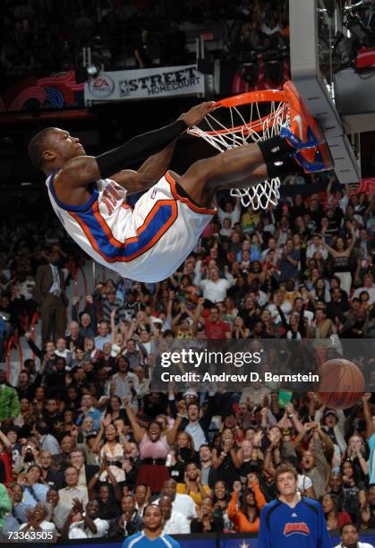 Nate Robinson of the New York Knicks grabs the rim and places his feet on the backboard during the Sprite Slam Dunk Competition at NBA All-Star...