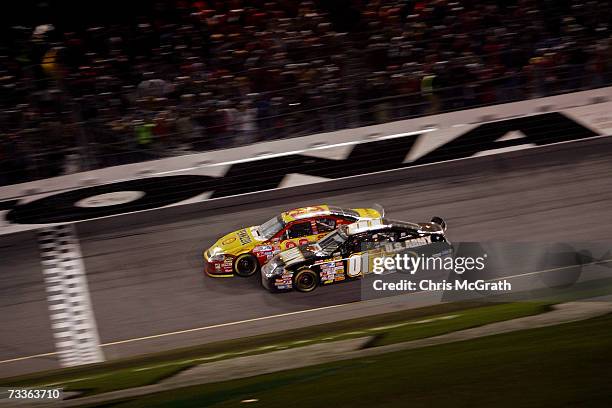 Kevin Harvick, driver of the Shell/Pennzoil Chevrolet, leads Mark Martin, driver of the U.S. Army Chevrolet, right before crossing the finish line to...