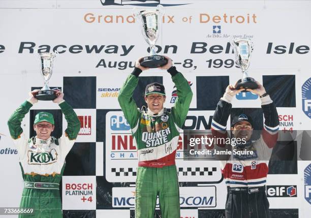 Derek Higgins of Ireland , driver of the Quaker State Lola T97/20 Buick holds aloft his trophy alongside second placed Oriol Servia and third placed...