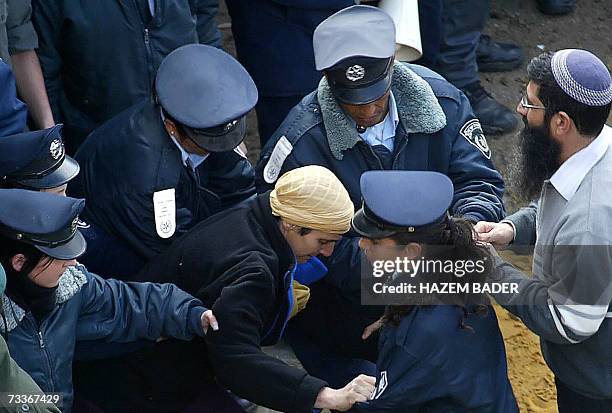 Israeli policemen try to remove Jewish settlers after they attacked Palestinians in the old city of Hebron 19 February 2007. Israeli police and...