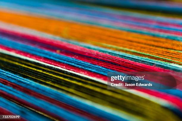 amaru women using colourful wool yarn on a loom to make traditional clothes. - gomitolo di lana foto e immagini stock