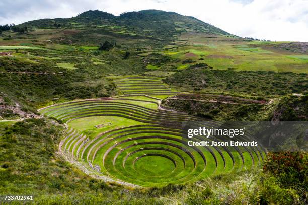 an inca site with stone wall terraces for growing agricultural crops by creating microclimates. - moray inca ruin stock pictures, royalty-free photos & images