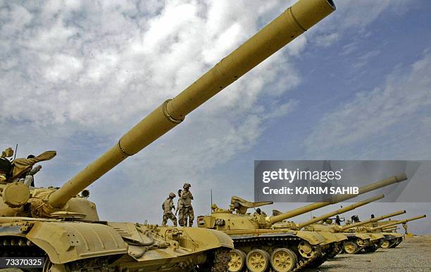 File picture dated 21 February 2006 shows Iraqi tank crews of the 9th Army Mechanized Division standing atop their renovated Soviet model T-72 tanks...