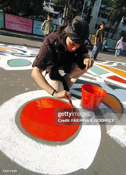Bangladeshi fine arts student paints on the ground in front of the Shahid Minar, in Dhaka, 20 February 2007, as part of preparations for the...
