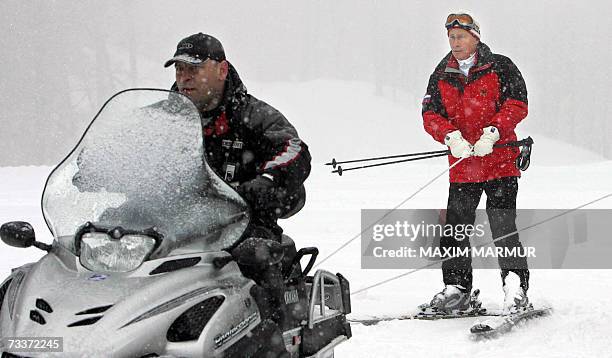 Sochi, RUSSIAN FEDERATION: A snowmobile pulls Russian President Vladimir Putin as he visits a mountainside of the Sochi resort, 20 February 2007....