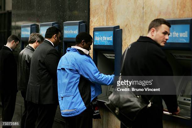 Customers use the cash machines on the side of a branch of Barclays Bank on February 20, 2007 in London. Barclays have today announce record profits,...