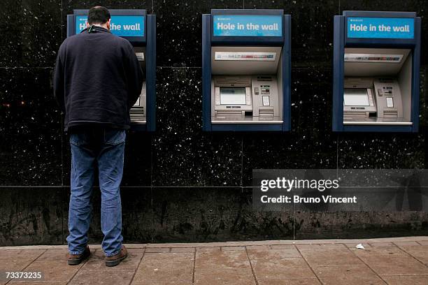 Customer uses a cash machine on the side of a branch of Barclays Bank on February 20, 2007 in London. Barclays have today announce record profits, up...