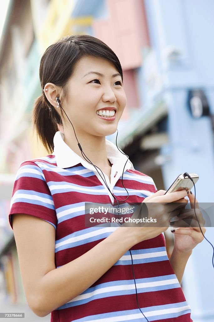 Close-up of a young woman listening to an MP3 player