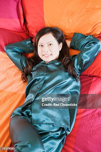 portrait of a young woman lying on the bed - negligée stock-fotos und bilder