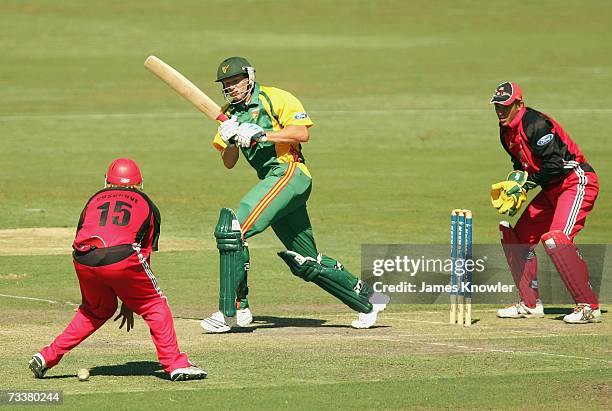 Chris Duval of the Tigers hits through the legs of Mark Cosgrove of the Redbacks during the Ford Ranger Cup match between the South Australian...