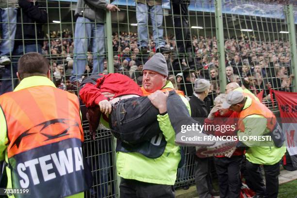 Stewarts evacuate people after clashes between Anti-riot Policemen and Manchester United's fans during the Champions League football match Lille vs....