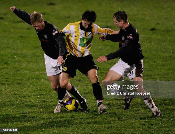 Timo Schulz and Carsten Rothenbach of Pauli tackle Denis Omerbegovic during the Third League match between Borussia Dortmund II and FC St.Pauli at...