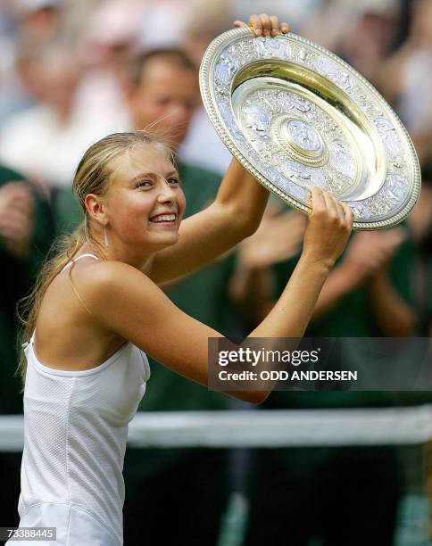 London, UNITED KINGDOM: Maria Sharapova of Russia holds up her trophy after her ladies' singles final match with Serena Williams of the US at the...