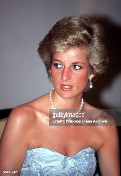 The Princess of Wales attends a banquet at the president's palace in Yaounde, Cameroon, wearing a blue Catherine Walker dress, March 1990.