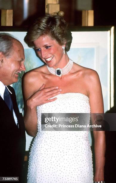 The Princess of Wales with President Gonz at a dinner in Budapest, May 1990. She wears a strapless gown by Catherine Walker, and a pearl choker with...