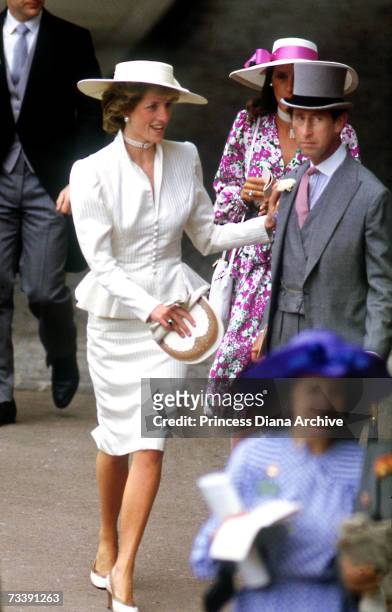 The Prince and Princess of Wales in the royal enclosure at Royal Ascot, June 1986. Princess Diana wears a cream peplum jacket and somerville hat.