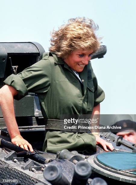 The Princess of Wales climbing into a tank during a visit to the Royal Hampshire regiment at Tidworth, June 1988. The Princess wore a boiler suit to...