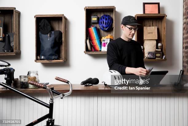 man in cycling accessories shop - bike ipad stock pictures, royalty-free photos & images