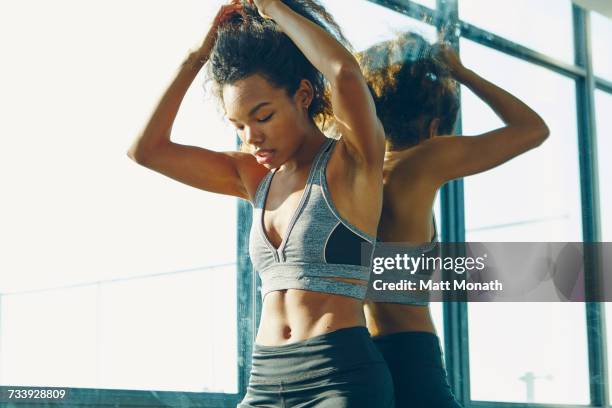 young woman in gym, taking a break from workout - bauchfreies oberteil stock-fotos und bilder