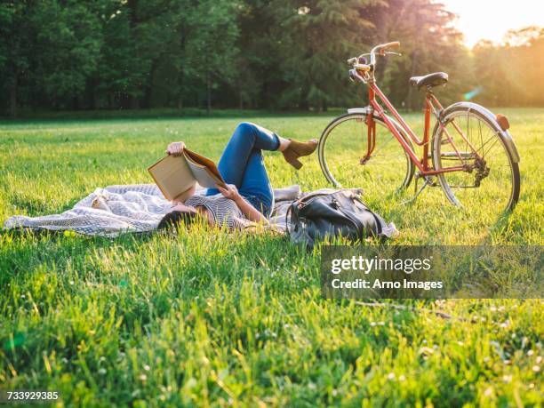 woman reading book on grass - twilight book stock pictures, royalty-free photos & images