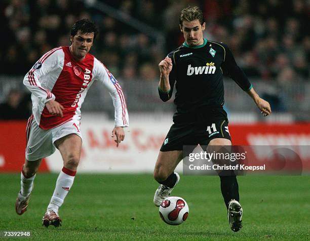 Miroslav Klose of Bremen shoots the ball as Roger of Ajax follows him during the UEFA Cup round of 32 second leg match between Ajax Amsterdam and...