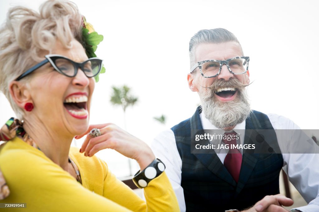 1950s vintage style couple laughing together at coast