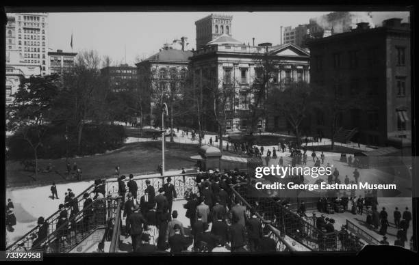 View of commuters as they enter and leave the elevated railroad station at City Hall Square and Park in downtown Manhattan, New York, New York, early...