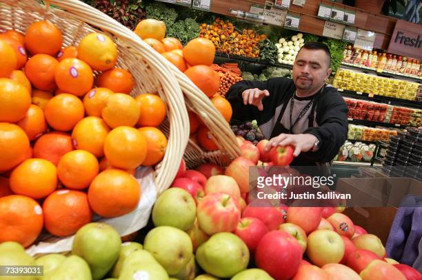 Whole Foods employee Cesar Martinez stocks shelves with apples at a Whole Foods Market February 22, 2007 in San Francisco, California. Whole Foods...