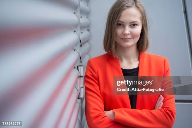 portrait of confident young businesswoman outside office building - business woman in red suit jacket stock pictures, royalty-free photos & images