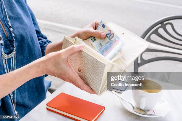 hand of mature woman removing euro note from purse at sidewalk cafe, fiesole, tuscany, italy - twenty euro note 個照片及圖片檔