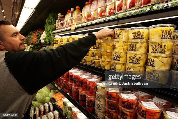 Whole Foods employee Cesar Martinez arranges shelves of fresh pineapple at a Whole Foods Market February 22, 2007 in San Francisco, California. Whole...