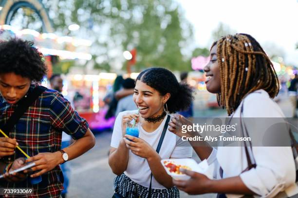 group of friends at funfair, boy looking at smartphone - slushies stock pictures, royalty-free photos & images
