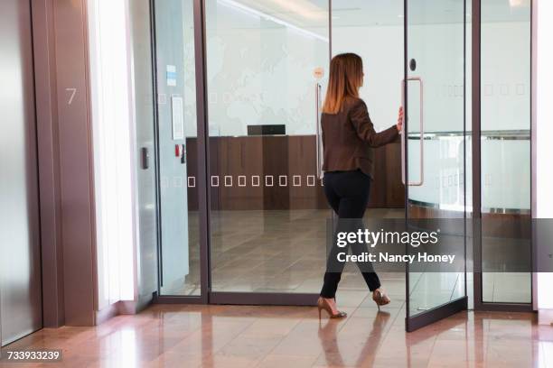 businesswoman going through office door - walking into door stock pictures, royalty-free photos & images