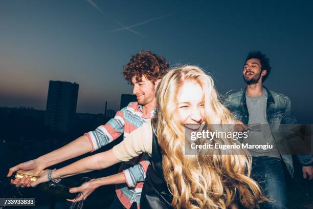 group of friends enjoying roof party - männer gruppe stock-fotos und bilder