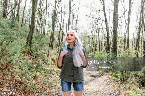 mature woman with long grey hair looking up from forest, scandicci, tuscany, italy - one woman only shorts 50s stock pictures, royalty-free photos & images