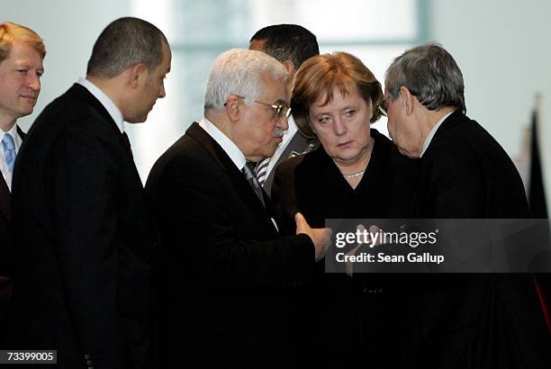 Palestinian President Mahmoud Abbas and German Chancellor Angela Merkel speak with the help of a translator prior to a press conference after talks...