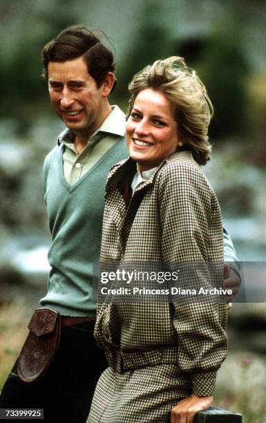 The Prince and Princess of Wales stand by the River Dee on the Balmoral estate during their honeymoon in Scotland, September 1981. The Princess wears...