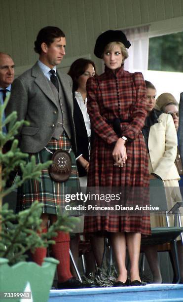 The Prince and Princess of Wales at the Braemar Highland Games in Scotland, September 1981. She wears a tartan suit by Caroline Charles and a tam...