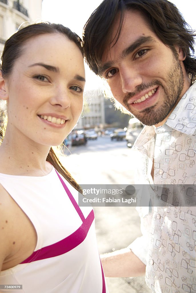 Young couple outdoors, smiling, portrait