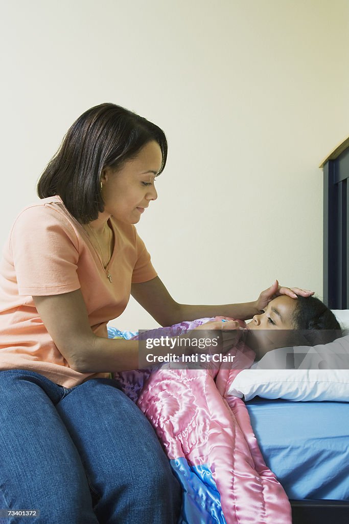 Mother checking her daughter's (6-7) temperature