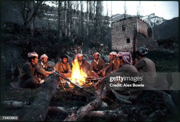 Within sight of his bomb damaged home, a Kurdish village headman, turned Peshmerga fighter, ponders the future, 12th May 1979. Beside him, sits the...