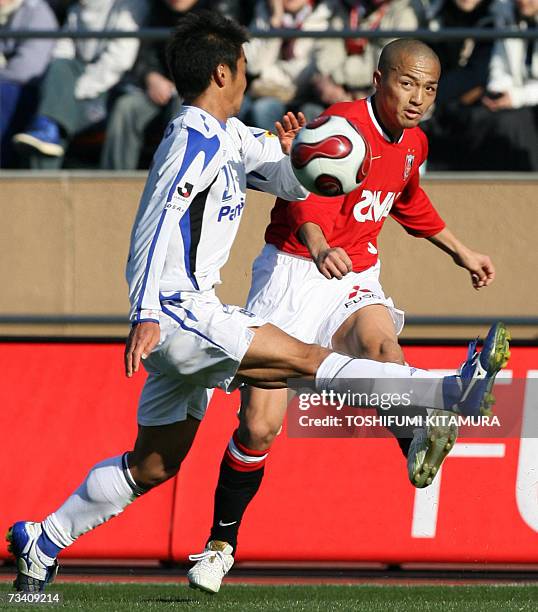 Urawa Reds midfielder Shinji Ono passes the ball as Gamba Osaka defender Akira Kaji follows him during their Super Cup in Tokyo, 24 February 2007....