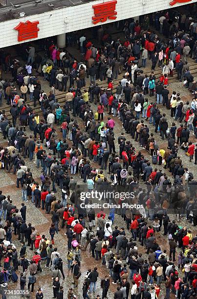 Passengers line up to buy train tickets at Caiyuanba Railway Station on February 24, 2007 in Chongqing Municipality, China. The number of travelers...