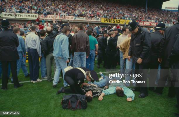 St John Ambulance volunteer attends to casualties on the pitch at Hillsborough football stadium in Sheffield, after a human crush at an FA Cup...