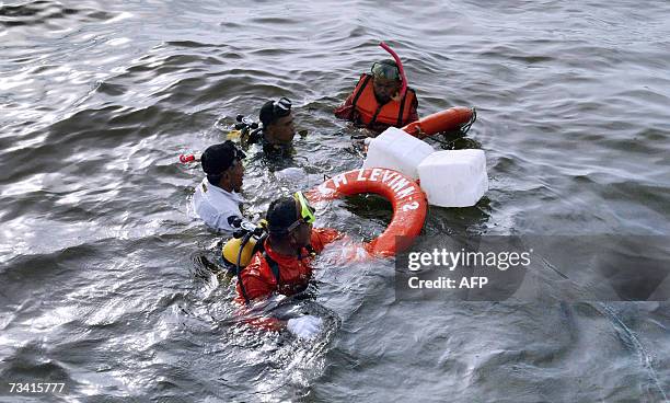 Indonesian rescue team members work on the localisation of a sank ferry, north of the Jakarta seaport, 25 February 2007. An Indonesian ferry gutted...