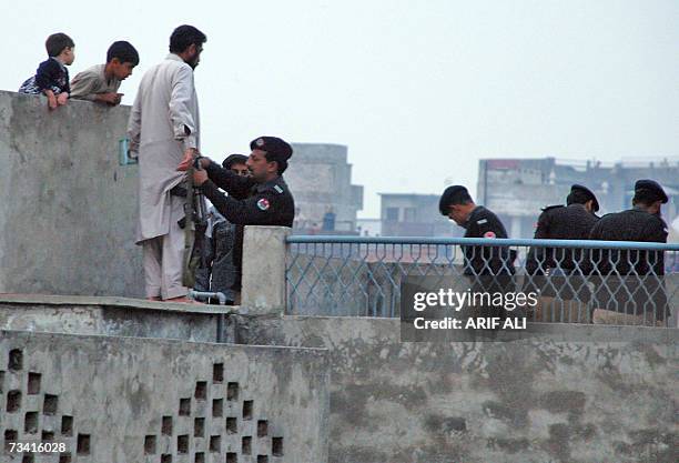 Pakistani policeman frisks a man for banned cords during the Basant or kite flying festival in Lahore, 25 February 2007. Kite flyers can use twine...