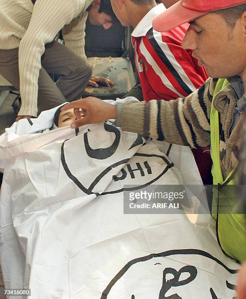 Pakistani rescue worker covers the face of boy Umar Farooq who was killed by kite cord during the Basant or kite flying festival in Lahore, 25...