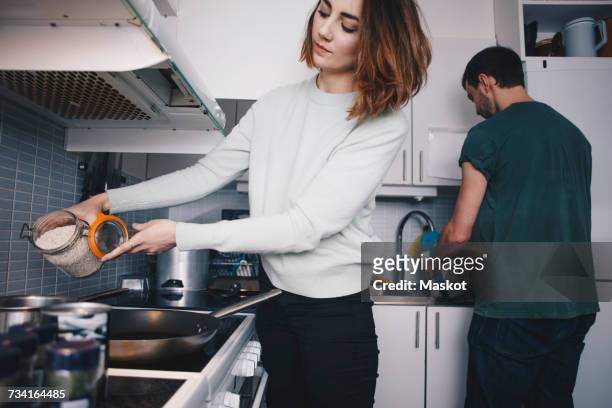 young roommates preparing food in kitchen - college apartment stock pictures, royalty-free photos & images