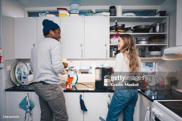 happy young roommates cooking in kitchen - roommate stock-fotos und bilder